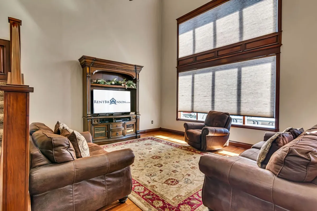 A cozy living area featuring a comfortable sofa, armchair, TV stand, and rug. The setup fosters relaxation, socializing, and movie nights—ideal for unwinding after a day of activities or for late-night films.