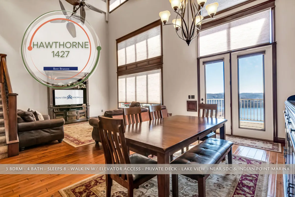 A cozy dining area with a large table positioned in front of floor-to-ceiling windows, offering stunning vistas of Table Rock Lake. The space is accented by an elegant chandelier and plush seating, ideal for memorable meals and gatherings with friends or family.